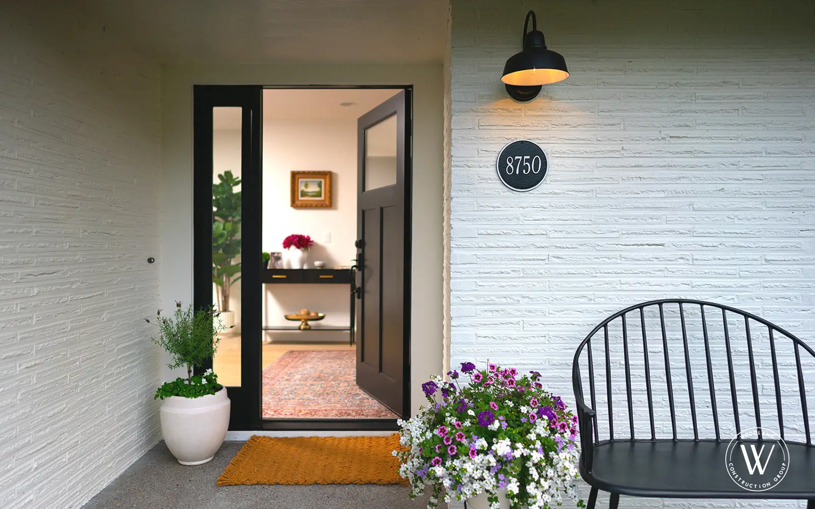 Hemlock front entry after: black front door, refreshed porch, and new stone hardscape
