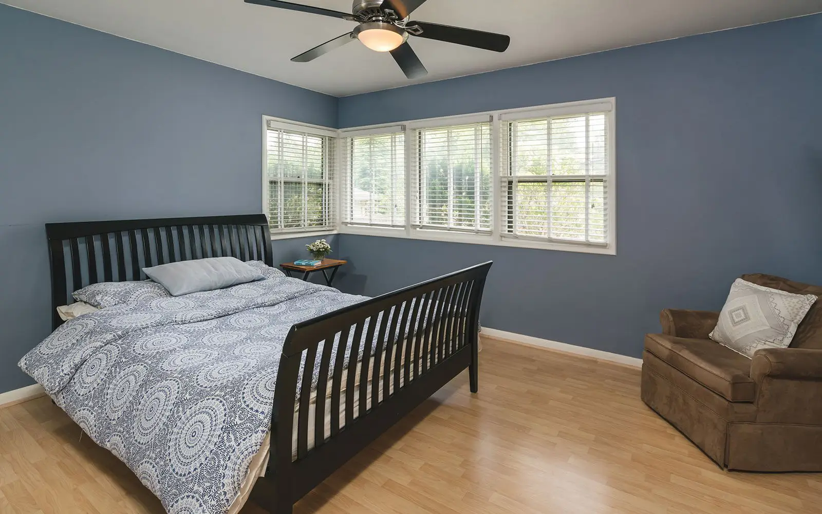 Hemlock secondary bedroom before: blue walls and a dark sleigh bed
