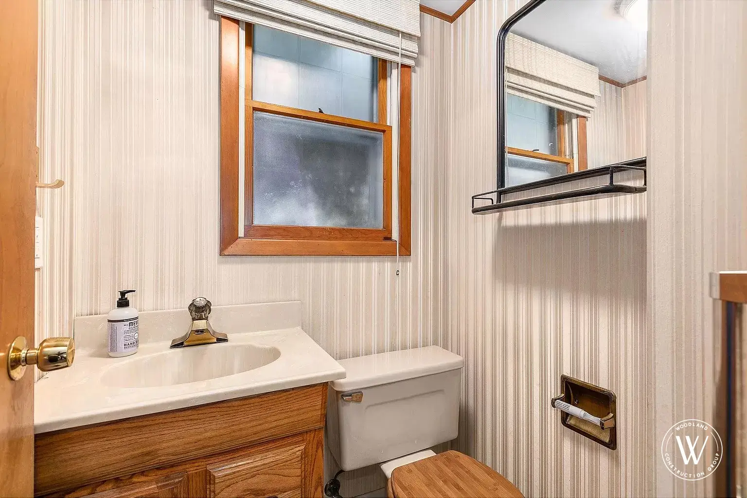 Berkshire bathroom before remodel, cramped powder bath with an oak vanity, cultured-marble sink, and striped wallpaper, Portland Oregon