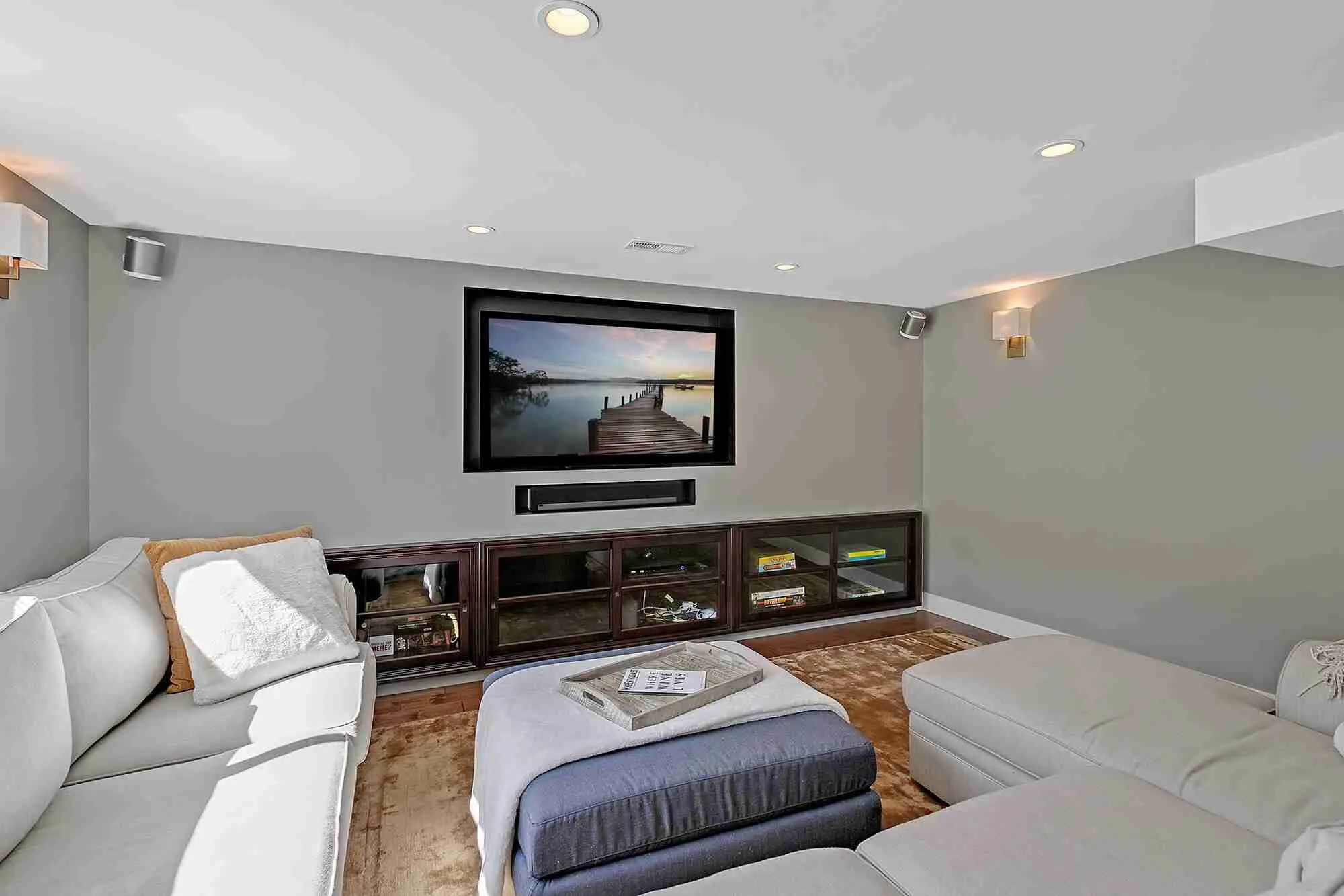 Hemlock basement remodel: finished media room with a built-in wall unit and sectional seating