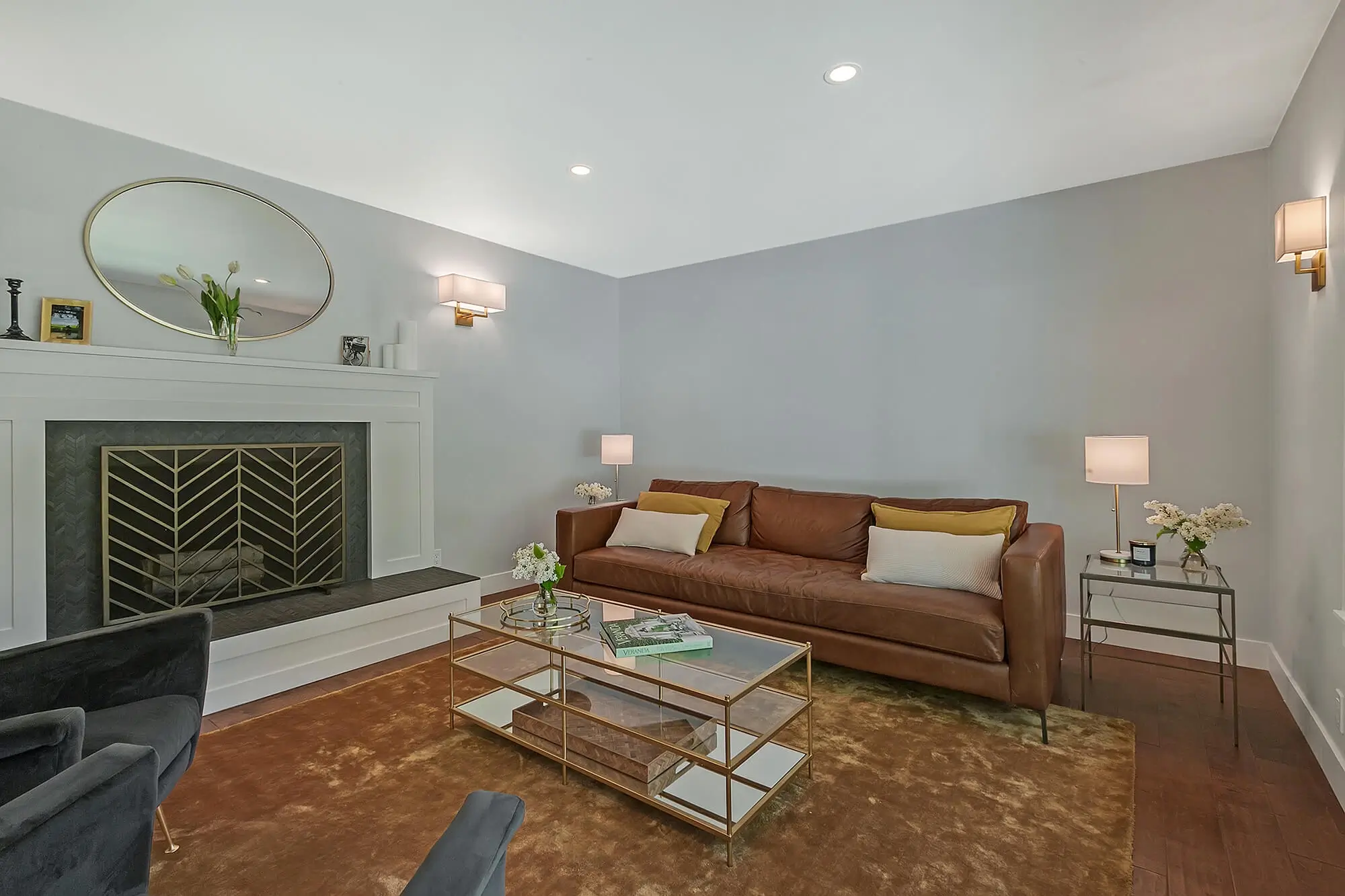 Restored Hemlock main-level living room with a white fireplace, leather sofa and a large picture window over the front garden