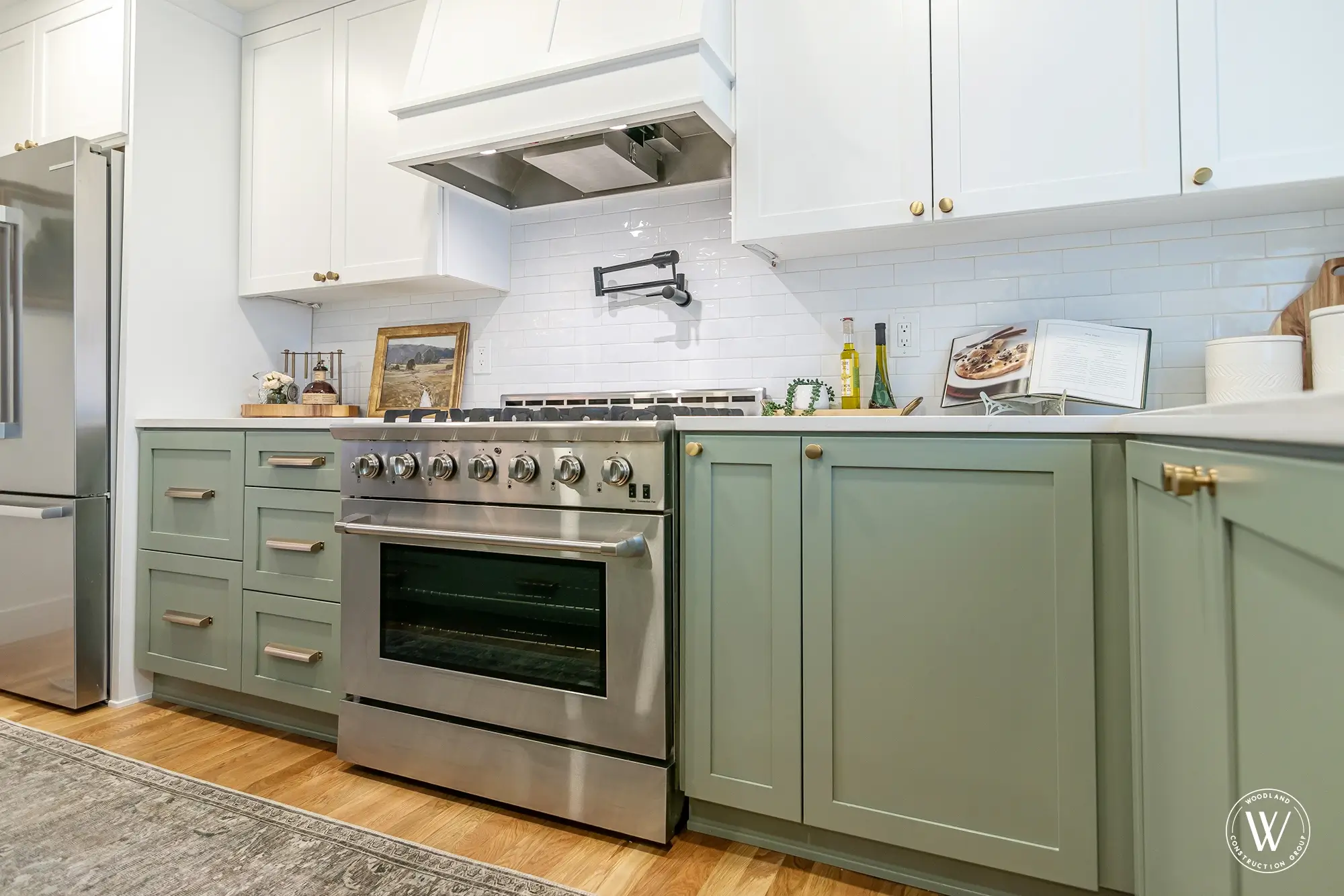Murray kitchen range wall with a professional stainless gas range, custom white hood, subway tile and a brass pot filler