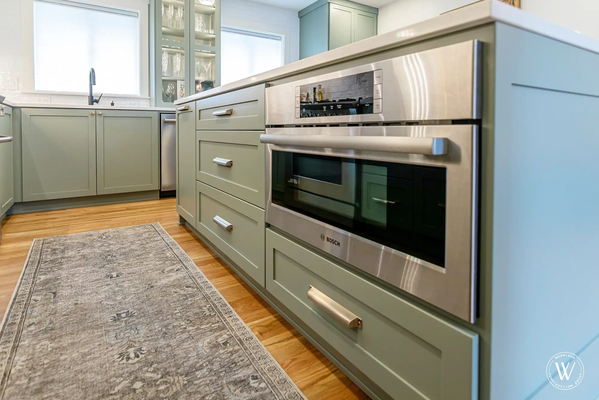 Murray kitchen island with a built-in Bosch speed oven set into the sage-green cabinetry