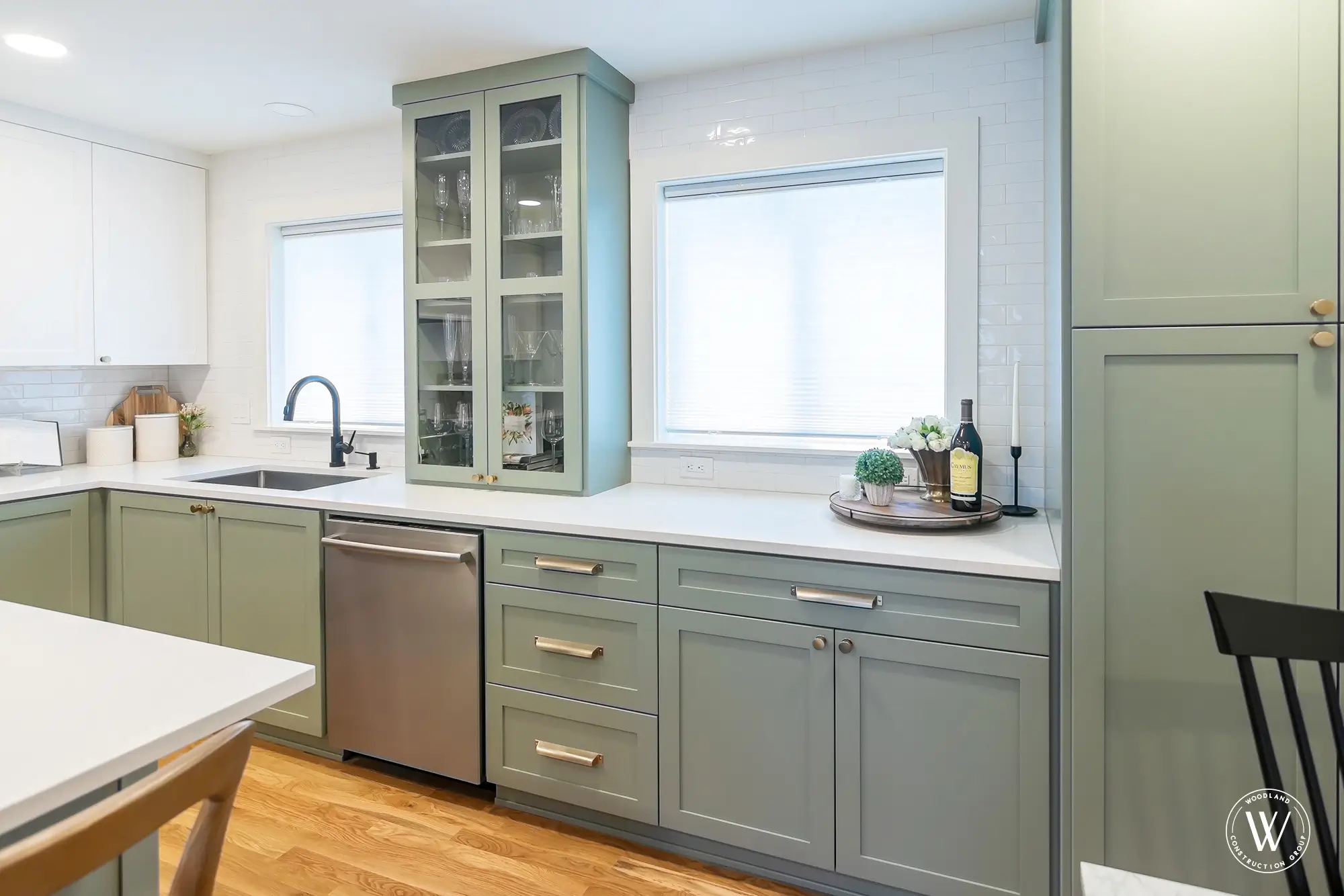 Murray kitchen sink wall with a black faucet, glass-front display cabinet and a paneled dishwasher