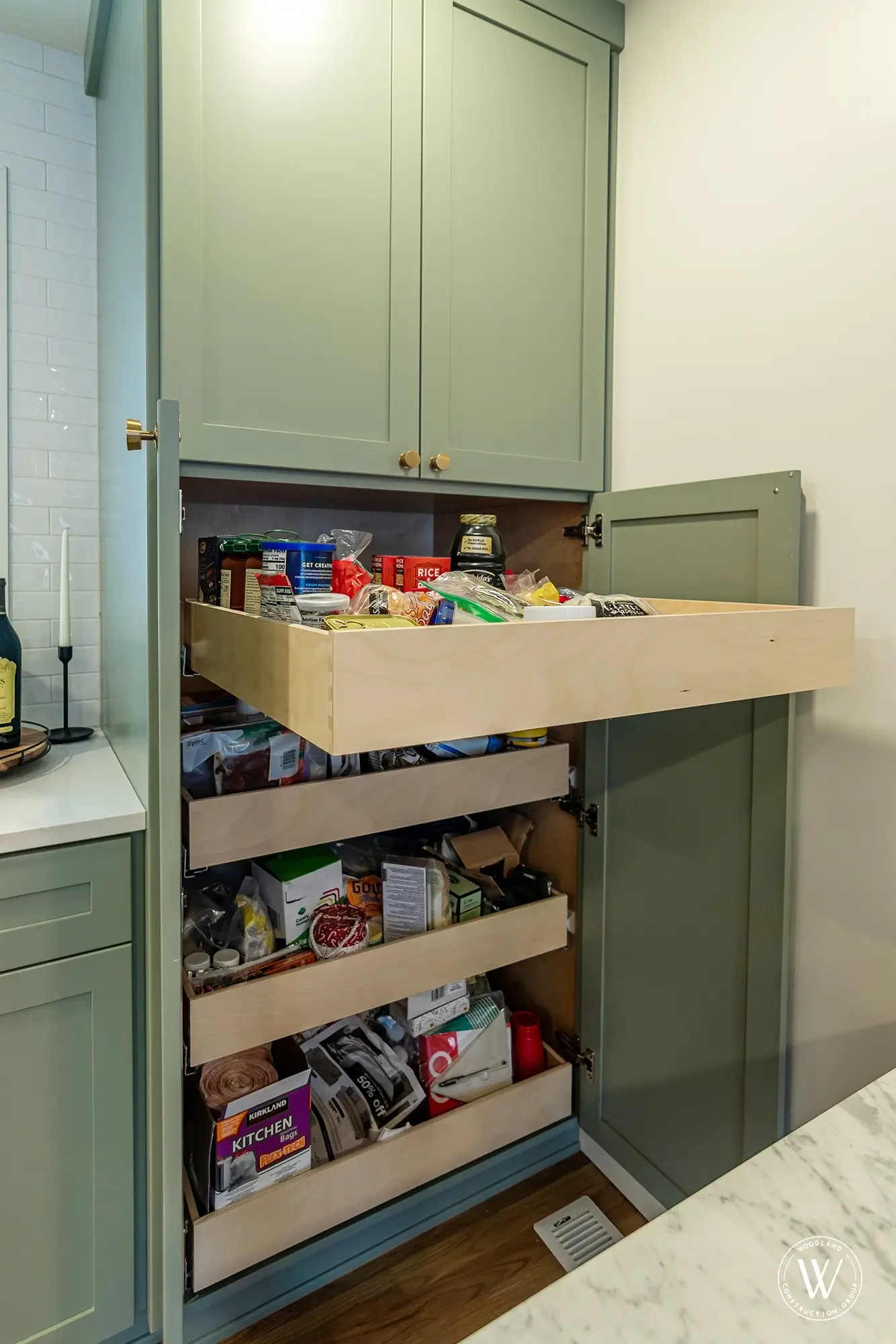 Murray pantry cabinet with three deep pull-out drawers fully extended and stocked