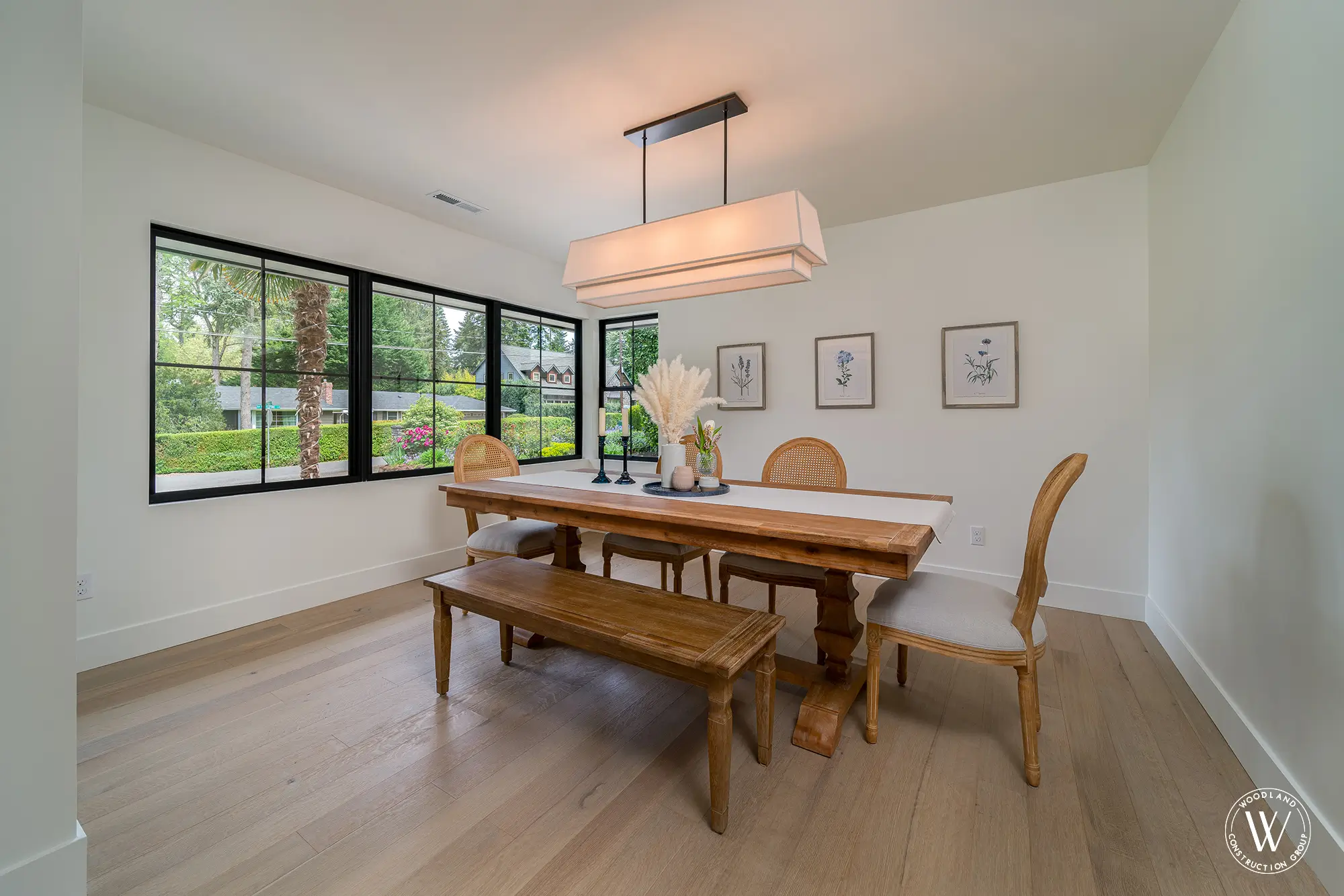 Whitepine dining room with a reclaimed-wood trestle table and bench beneath black-framed windows