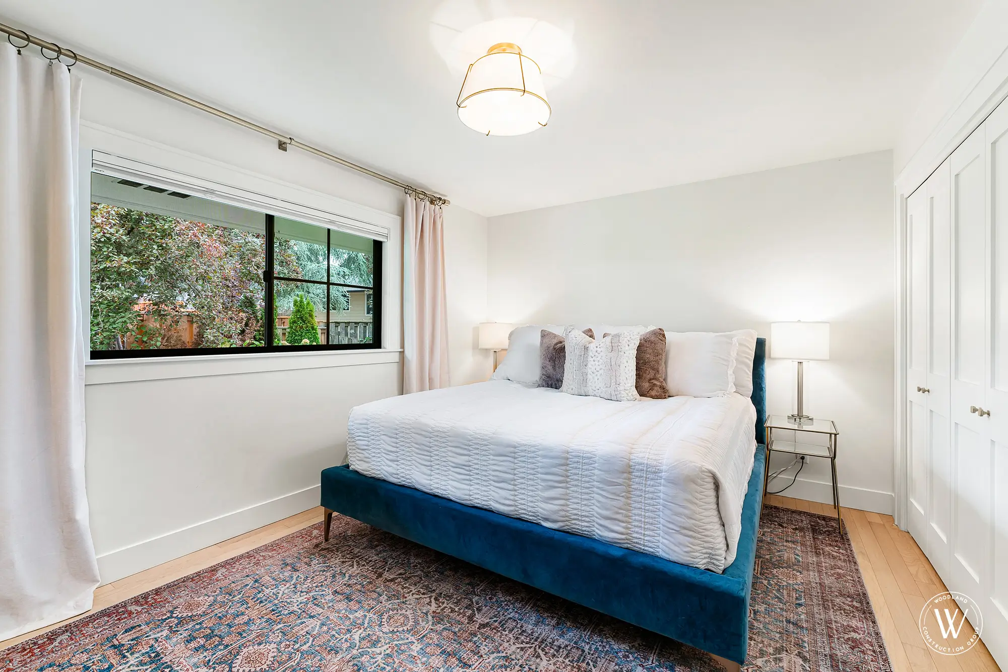 Berkshire bedroom with a blue velvet upholstered bed frame and a built-in closet, white-oak flooring