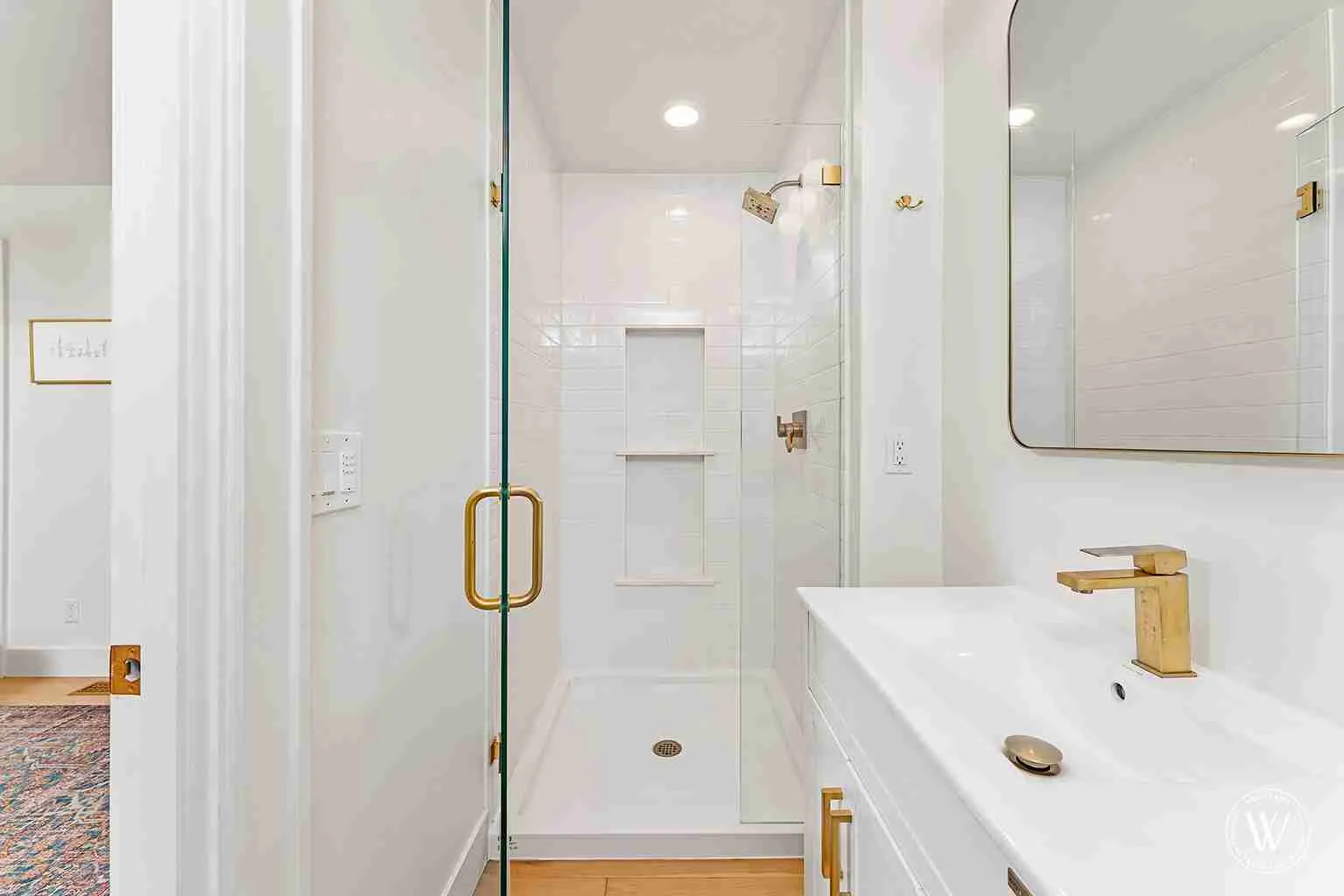 Berkshire bathroom after remodel, frameless glass walk-in shower with a subway-tiled niche and brushed-brass fixtures, Portland Oregon